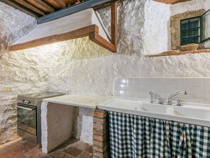 Een koelkast, een oven, een vaatwasser, kookgerei, borden en bestek