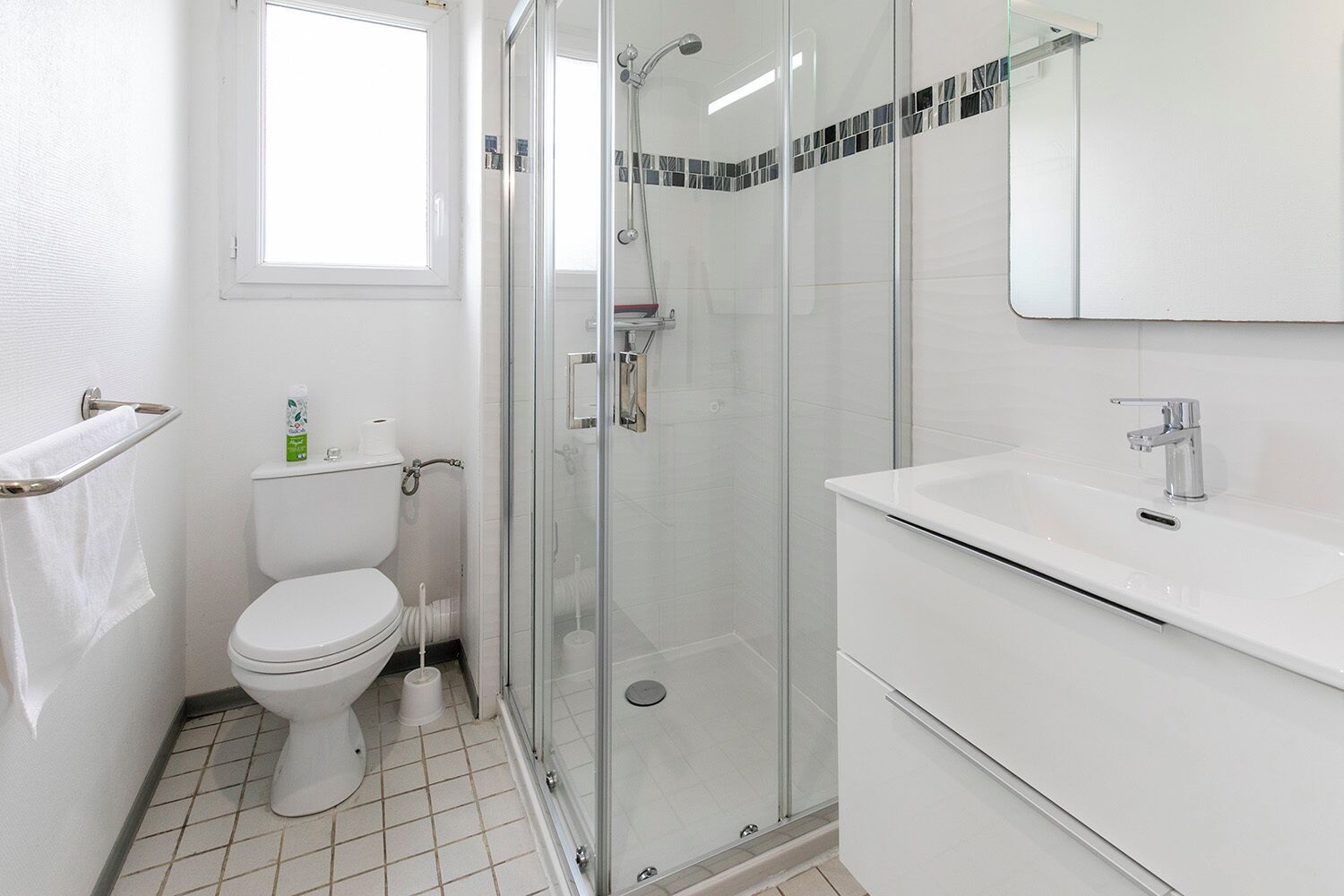 A modern bathroom with a toilet, shower, and sink.