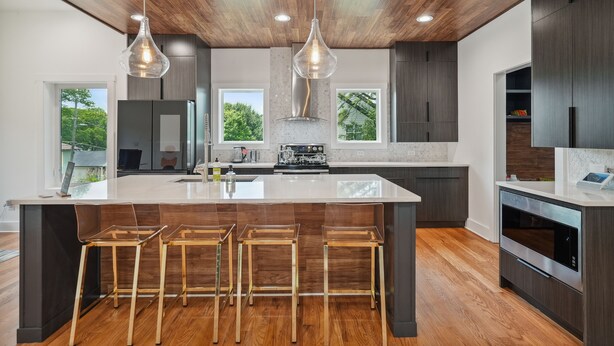 A modern kitchen with a large island, bar stools, and pendant lighting. - New Modern 4BR Smart Home Downtown Atlanta GWCC (Atlanta)