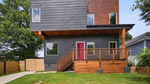 A modern two-story house with a wooden deck and a red door. - New Modern 4BR Smart Home Downtown Atlanta GWCC (Atlanta)