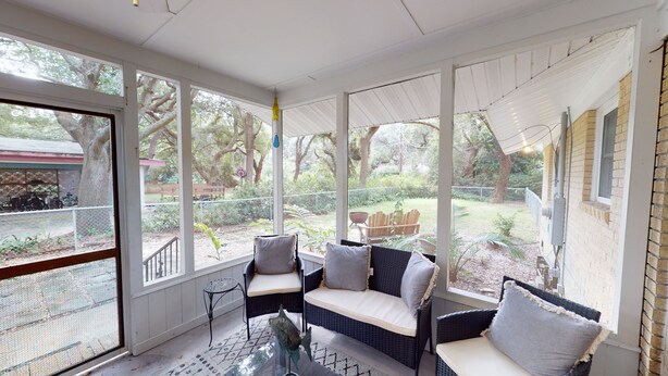 Un solarium con mobiliario de mimbre y vistas al jardín.