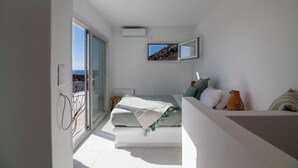 A modern bedroom with a bed, a television, and a view of the outdoors. - Villa Bella, Mikri Vigla.  Private pool, jacuzzi & amazing views. Sleeps 10+. (Naxos)