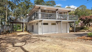 Ein zweistöckiges Haus mit Balkon, Garage und überdachter Terrasse.