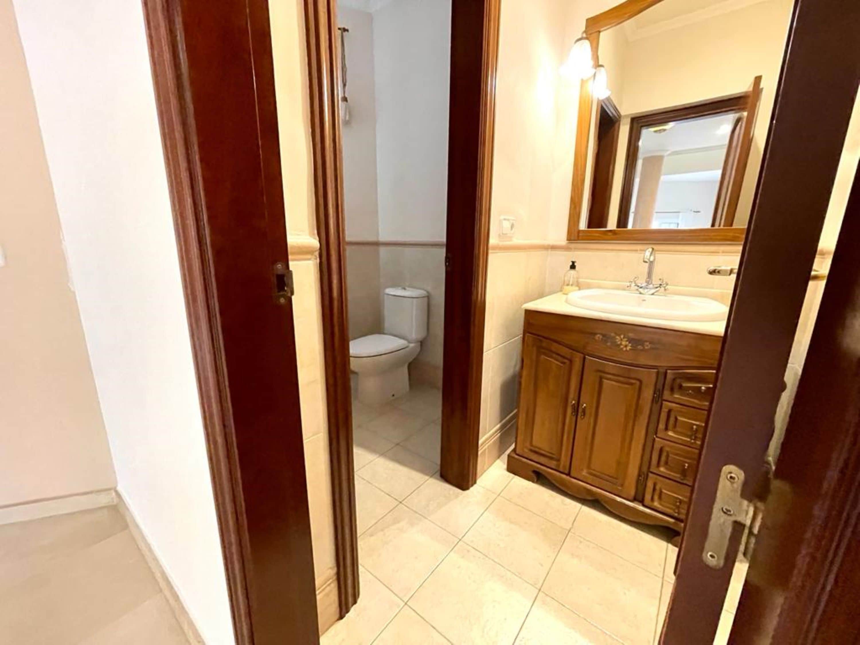 Un bagno con il water, un lavandino e uno specchio.