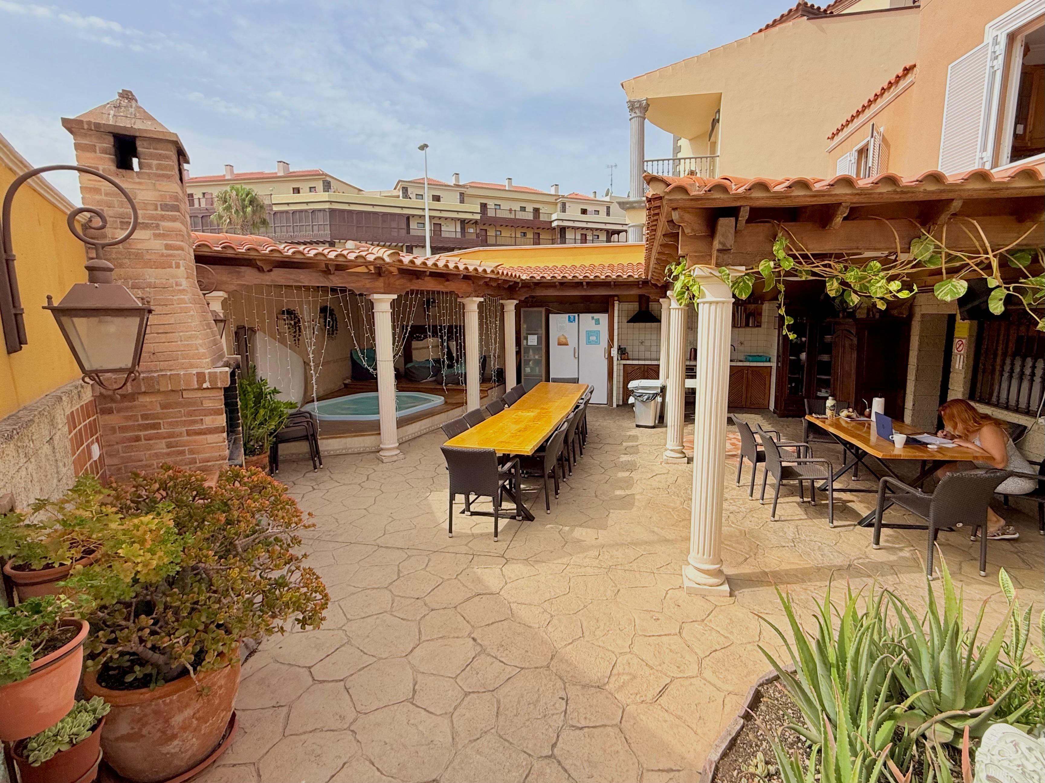 A courtyard with a pool, outdoor seating, and a brick structure.
