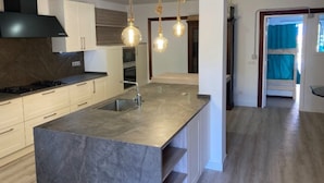 A modern kitchen with a marble island, stainless steel appliances, and pendant lighting. - Duque Nest Hostel (Adeje)