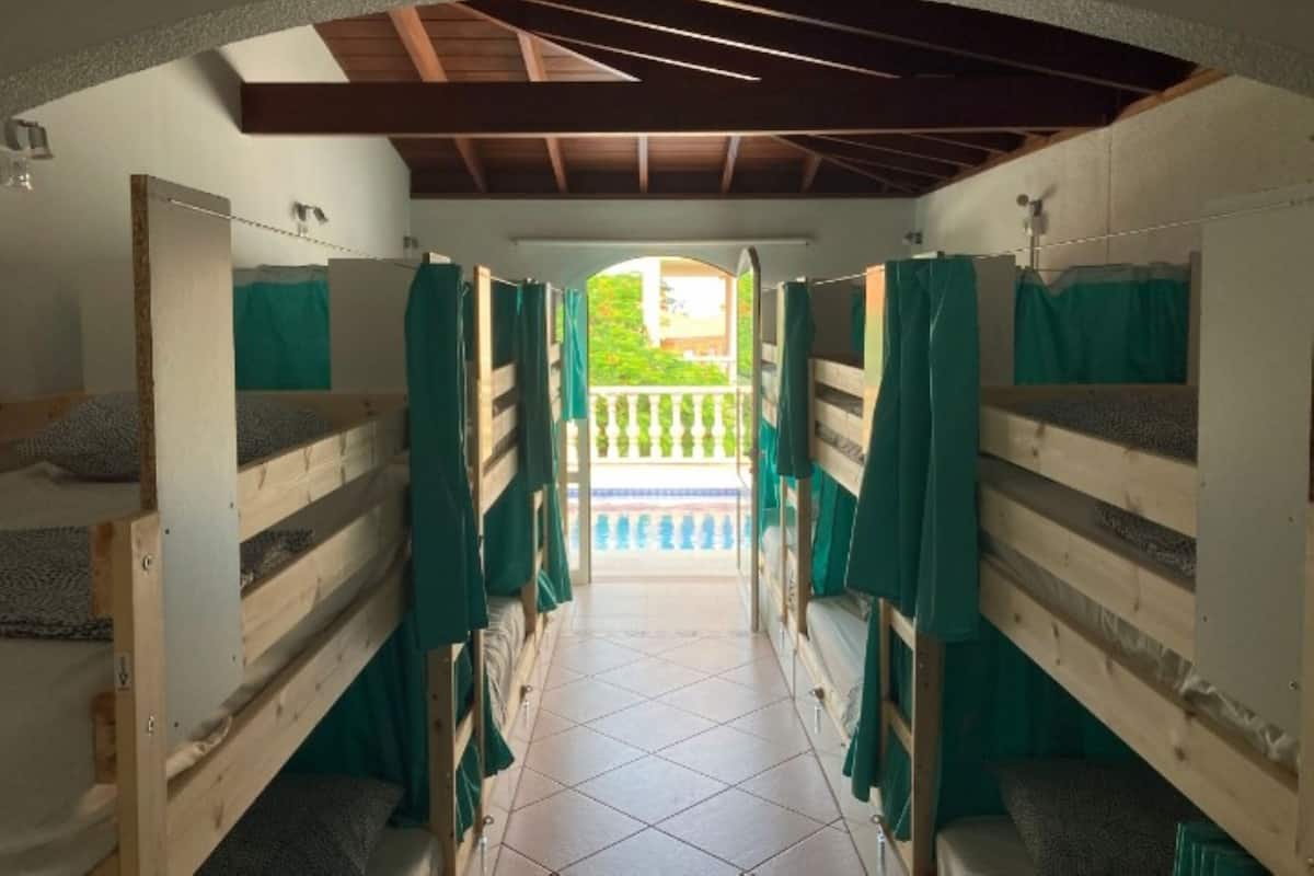 A corridor with bunk beds, a tiled floor, and a view of a balcony.