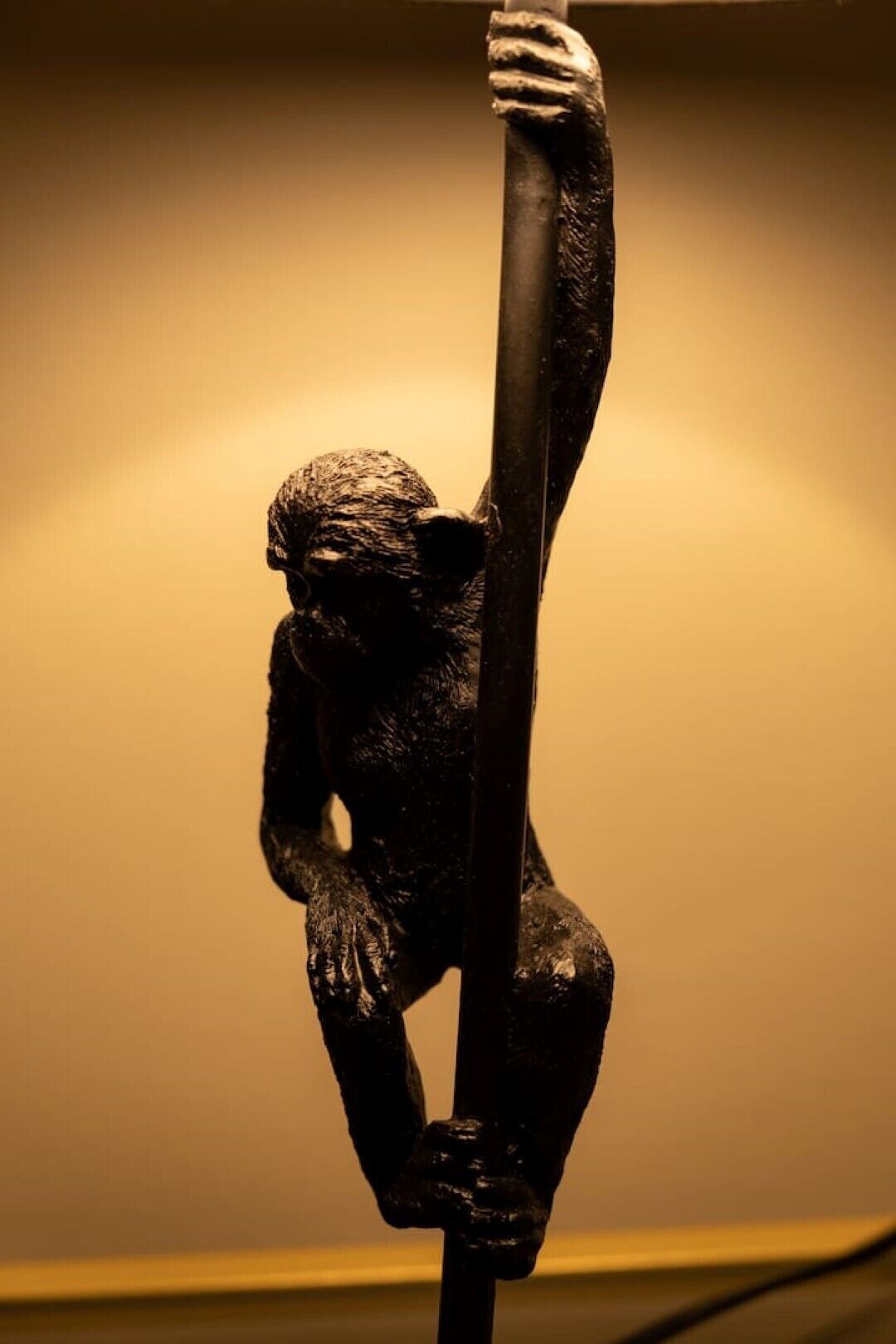 Una escultura de una figura humana sosteniendo un poste vertical.