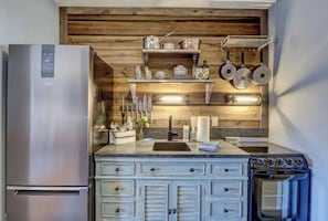 Kitchen features a stainless steel refrigerator, oven, and ample storage in the drawers.