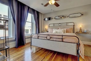 Relax in a spacious bedroom with a large bed, two bedside tables, and a ceiling fan.