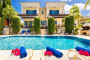 A two-story building with a swimming pool, lounge chairs, and a barbecue area. - Villa Galina - Five Bedroom Villa, Sleeps 10 (Neo Chorio)