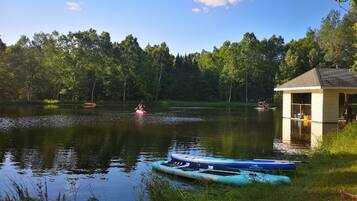Un chalet au bord du lac, doté d’un quai, entouré d’arbres et bordé d’une eau calme.