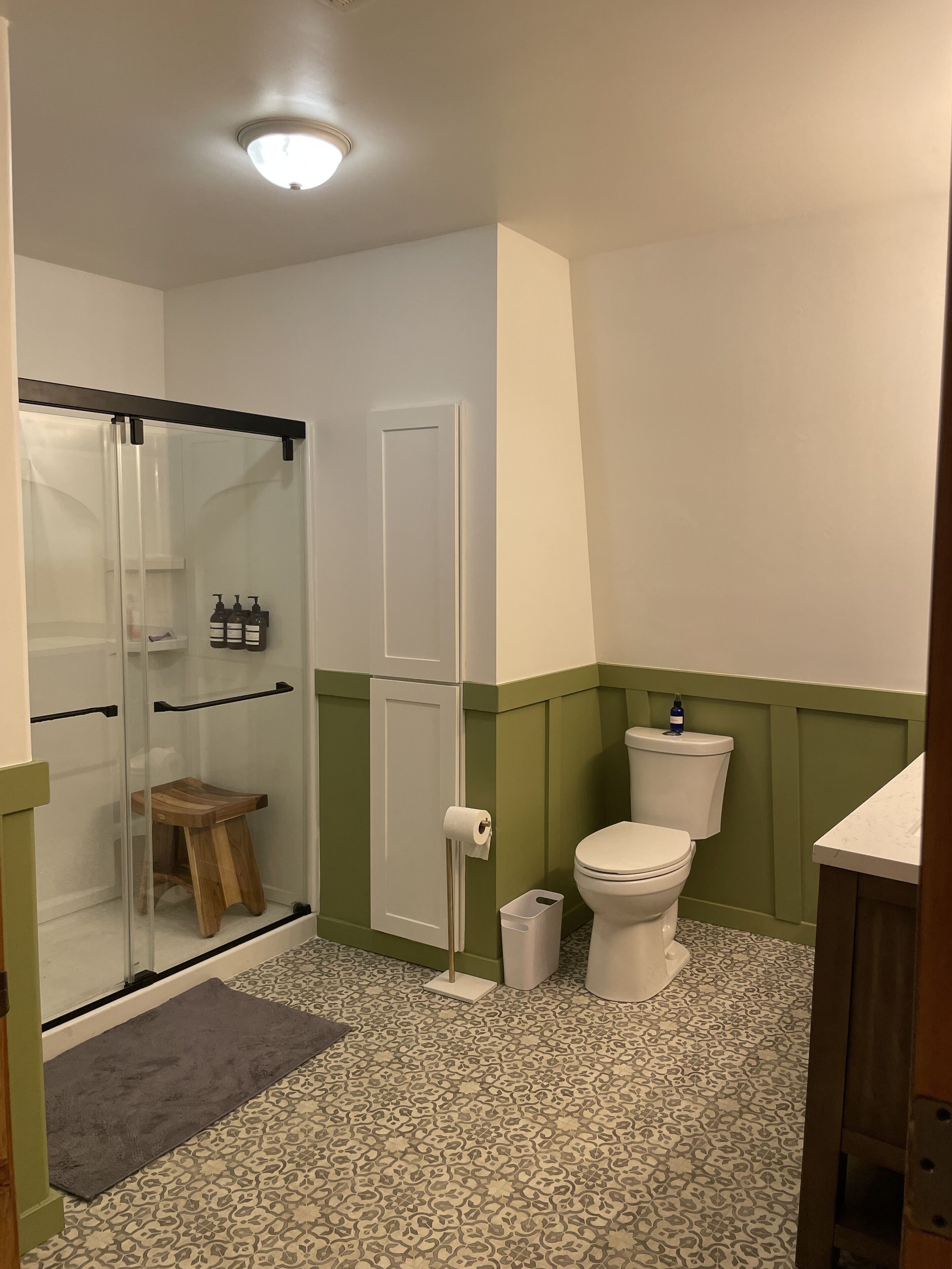 A bathroom with a shower, toilet, and sink.