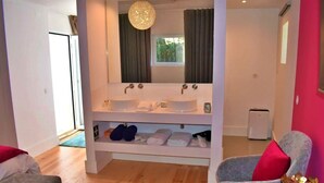 A bathroom with two sinks, a mirror, and a towel rack.