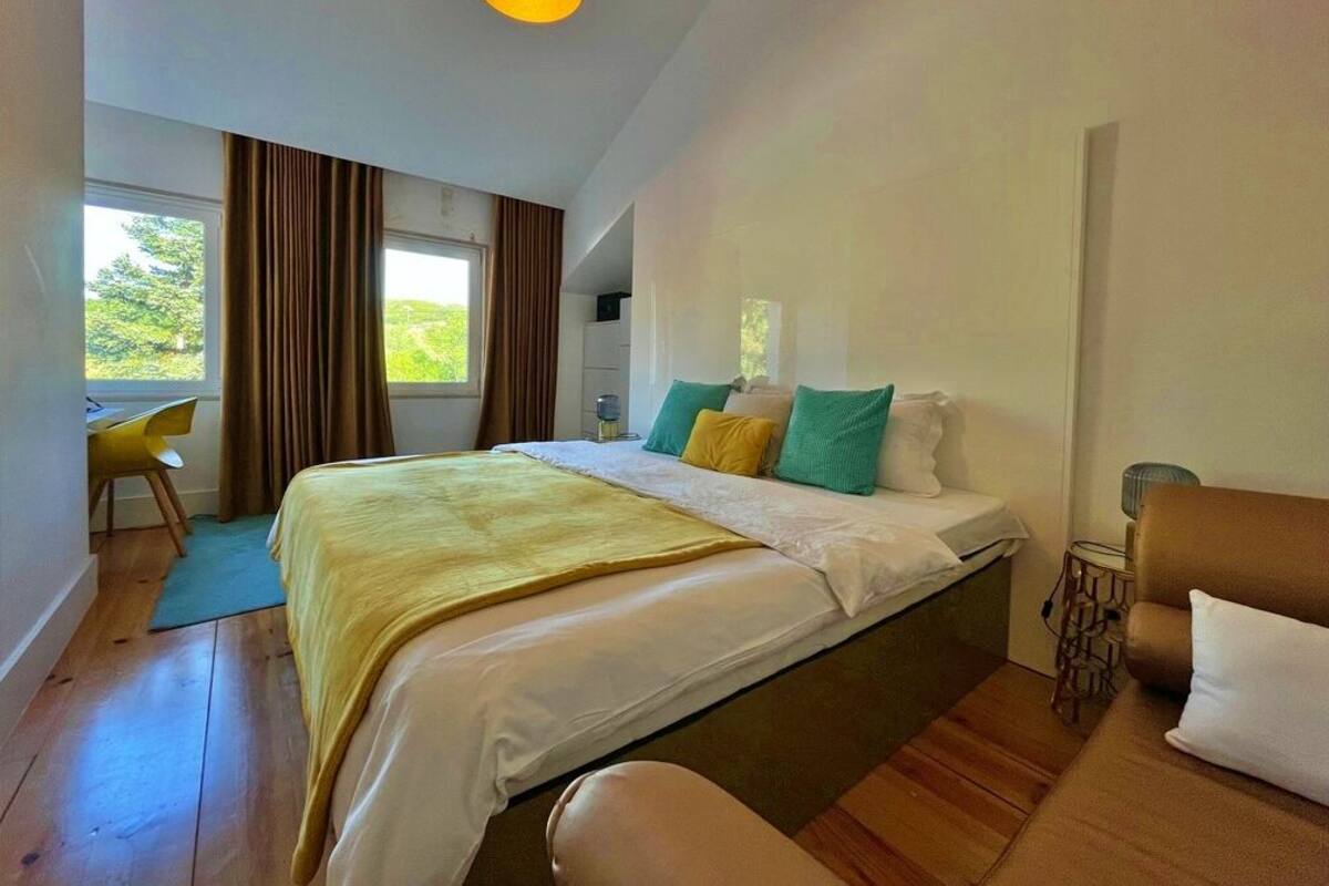 A bedroom with a bed, a desk, and a chair.