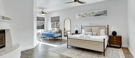 A bedroom with a bed, nightstand, and ceiling fan.