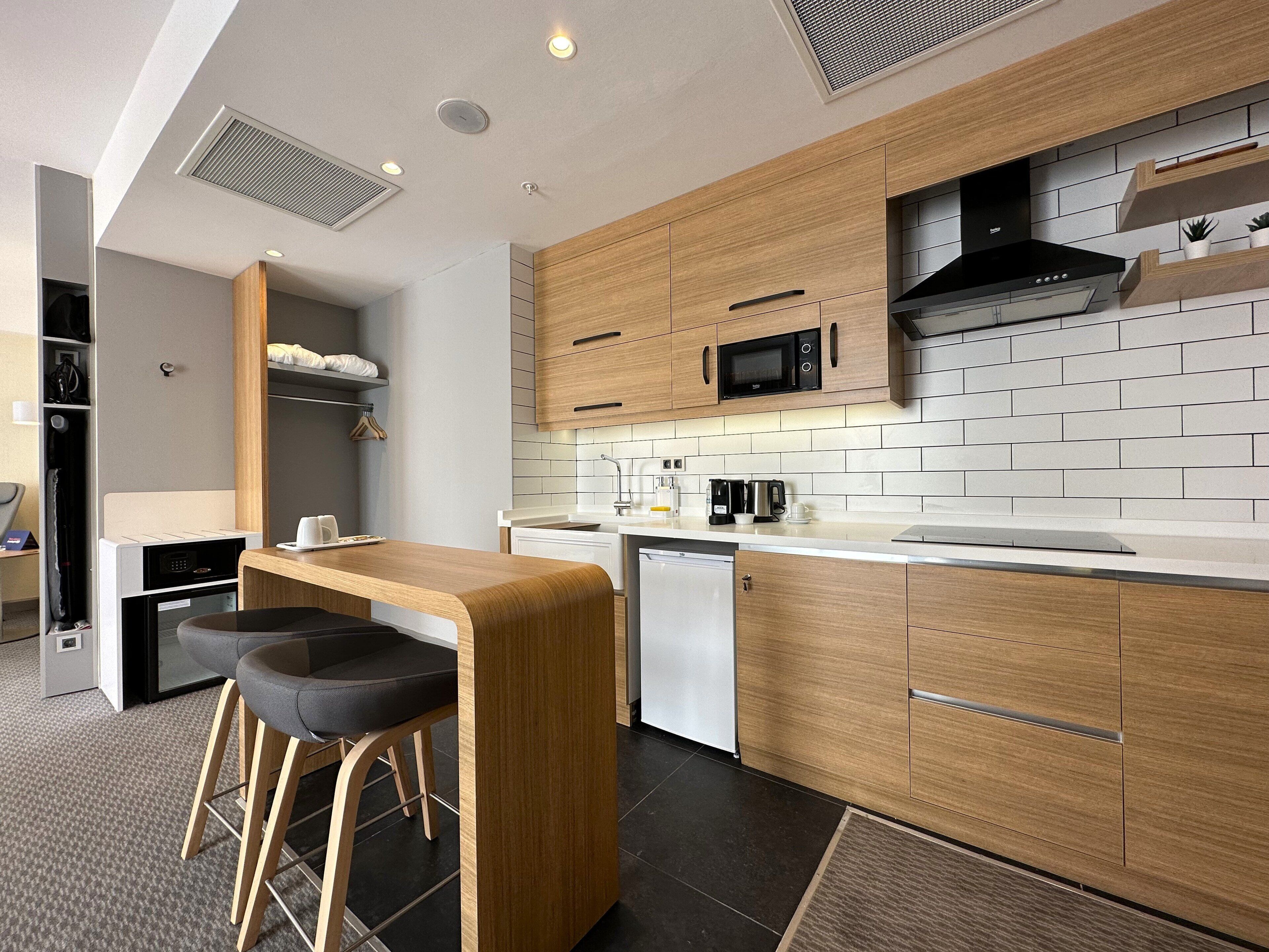 A modern kitchen with wooden cabinets, a microwave, and a coffee maker.
