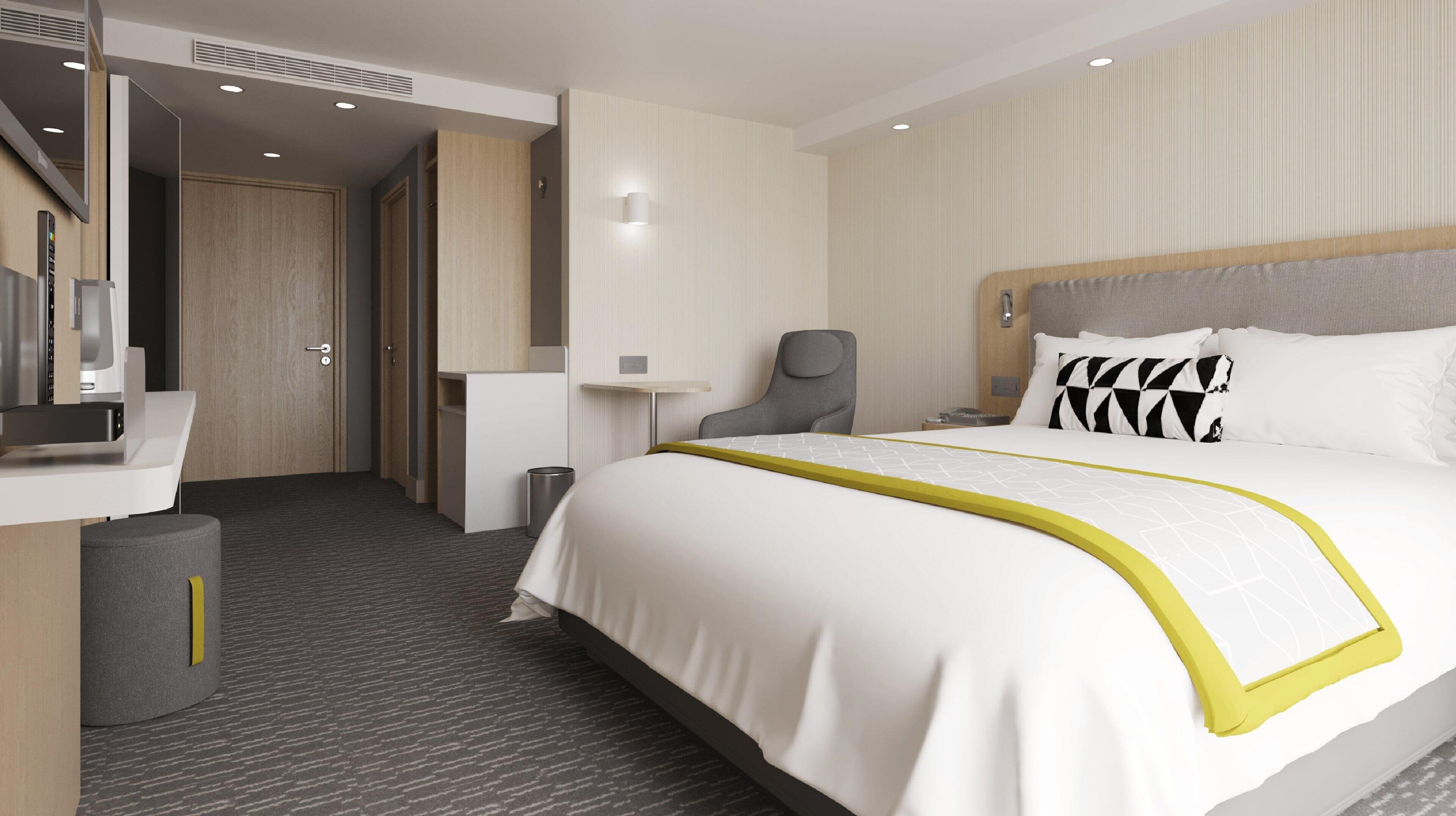 Ein modernes Hotelzimmer mit einem großen Bett, einem Schreibtisch, einem Sessel und einem kleinen Tisch.