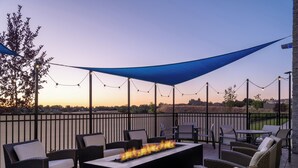 An outdoor patio with wicker furniture, a fire pit, and string lights. - Holiday Inn Express and Suites Meridian-Boise west by IHG (Meridian)