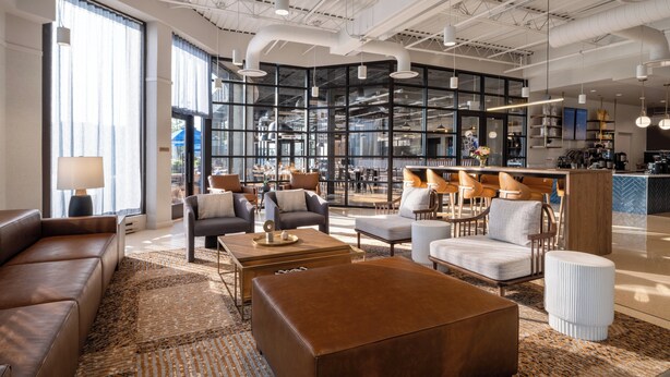 A modern lounge area with leather sofas, a coffee table, and a patterned rug.