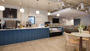 A modern kitchen with a herringbone tile backsplash, a coffee machine, and a refrigerator.