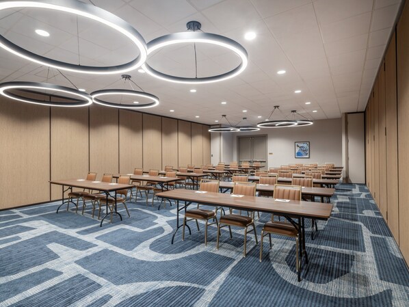 A conference room with round tables, chairs, and modern circular ceiling lights. - Holiday Inn Chicago O'Hare – Rosemont by IHG (Rosemont)