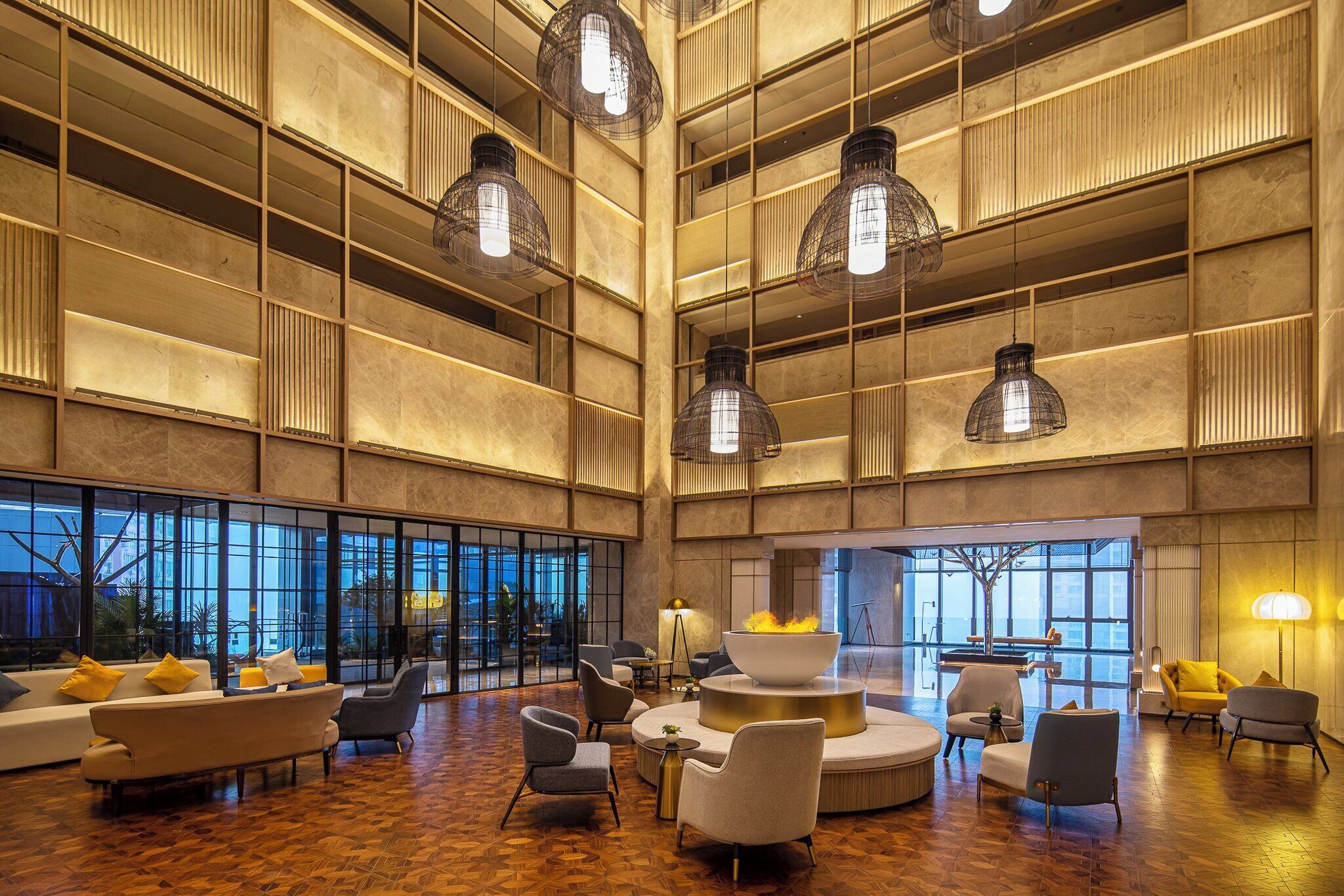 A spacious lobby with high ceilings, large windows, and modern furniture.
