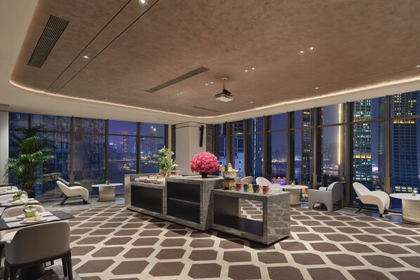 A modern hotel lobby with a reception desk, seating area, and large windows offering city views. - voco Chongqing Chaotianmen by IHG (Chongqing)