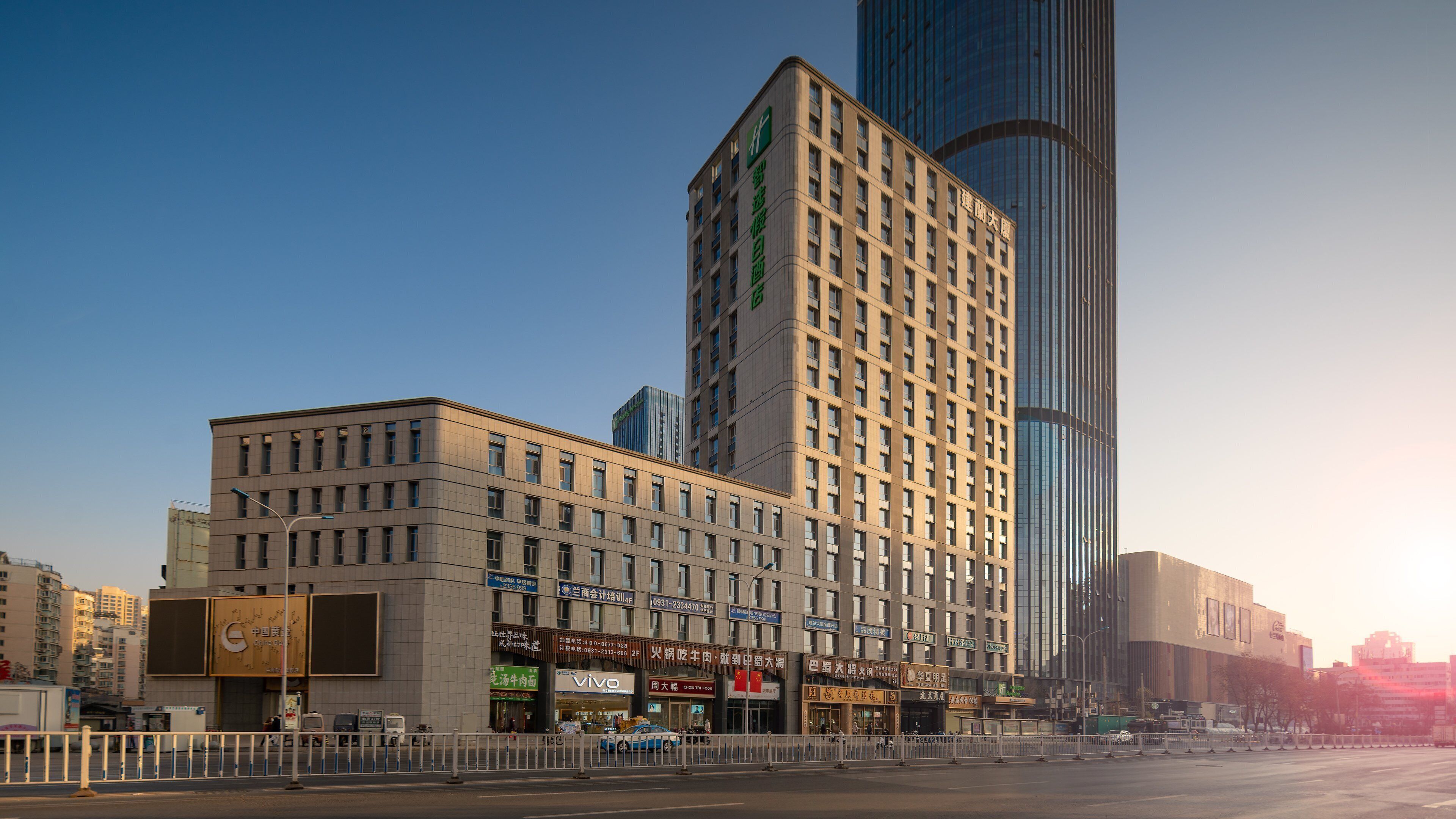 A multi-story hotel with a modern facade, featuring a prominent entrance and signage for various amenities.