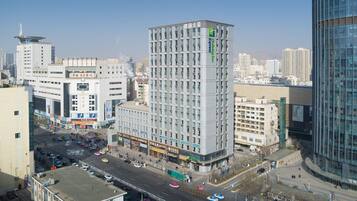 A multi-story hotel with a modern architectural design, featuring a prominent corner location with a view of the surrounding cityscape.