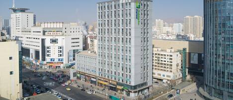 A multi-story hotel with a modern architectural design, featuring a prominent corner location with a view of the surrounding cityscape.