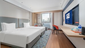 A modern hotel room with a large bed, a desk, a chair, and a city view. - Holiday Inn Express Lanzhou Jianlan by IHG (Lanzhou)
