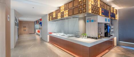A modern kitchen area with a central island, wooden paneling, and a digital coffee machine.
