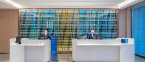 A reception area with two reception desks, a decorative glass partition, and a blue sign indicating "Diamond Elite" and "Platinum Elite" services.