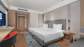 Una habitación de hotel con cama, mesita de noche y escritorio con silla.