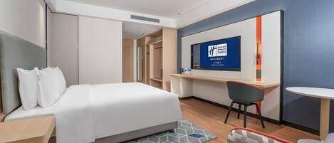 Habitación de hotel con cama, escritorio, silla y televisor mostrando el logotipo de Holiday Inn Express.