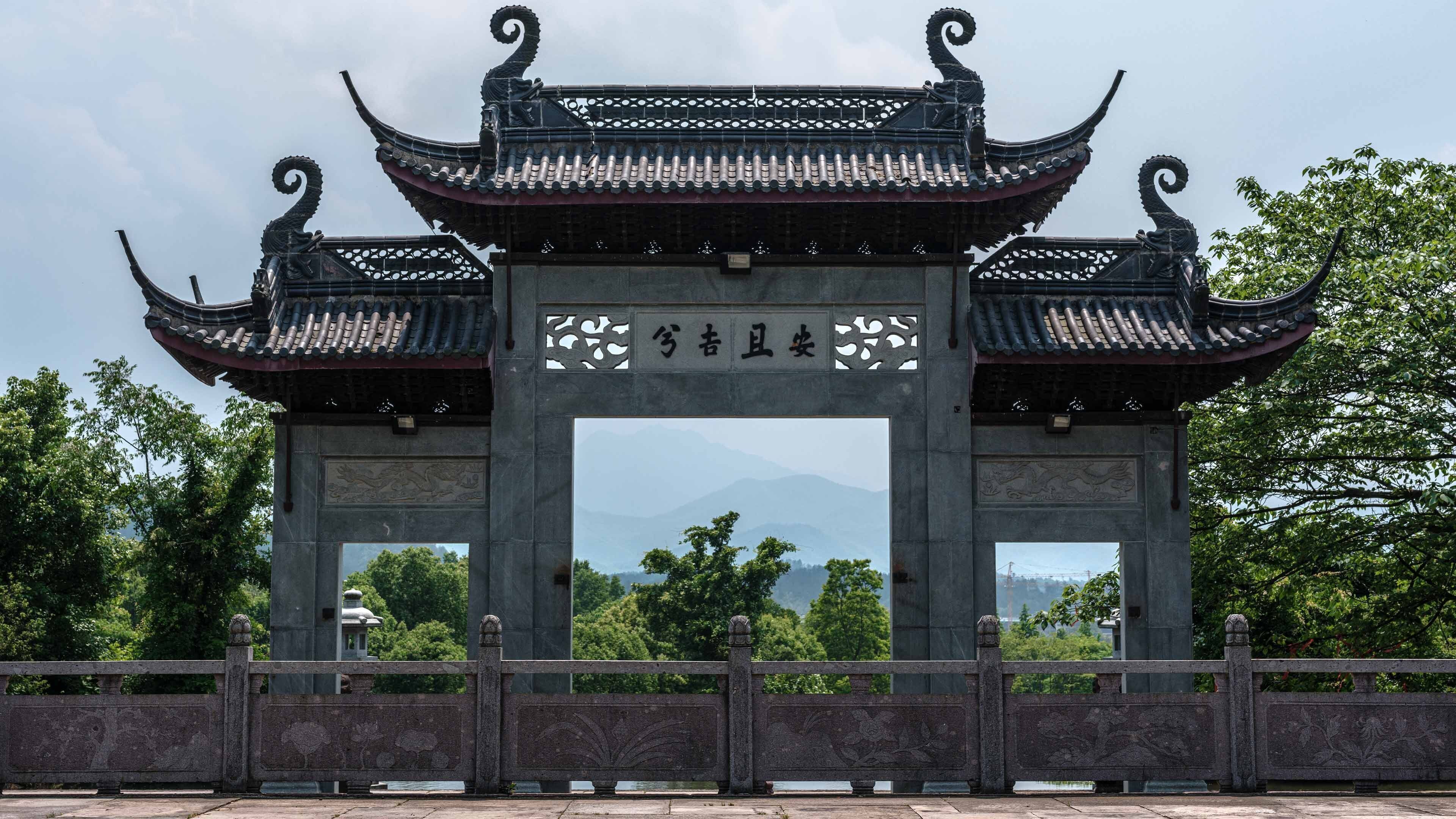 Una puerta tradicional china con tallas intrincadas y un letrero con caracteres chinos.