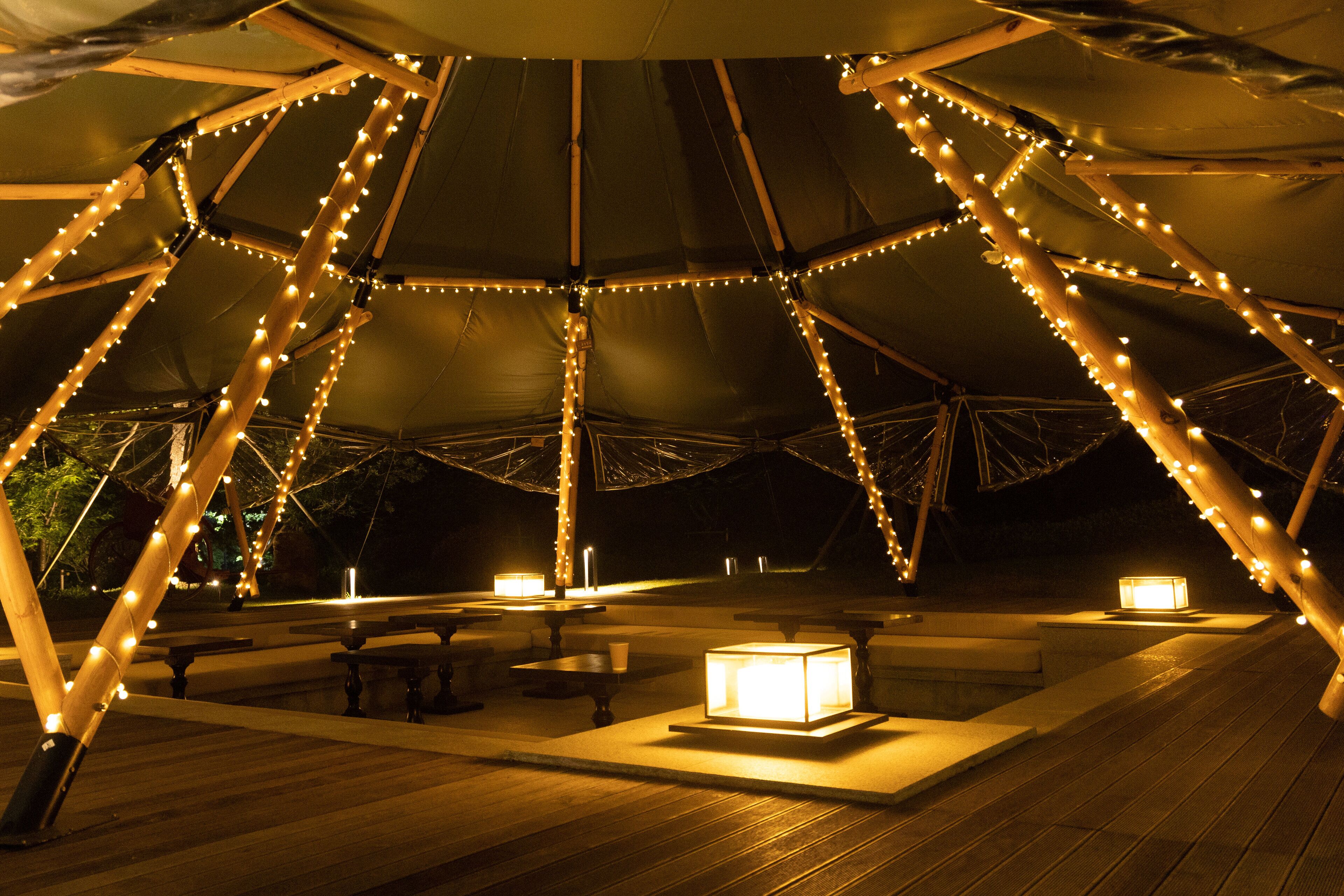 A tent-like structure with string lights and tables.