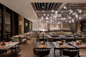 A modern restaurant interior with multiple dining tables, chairs, and a bar area. - Hotel Indigo Anji by IHG (Huzhou)