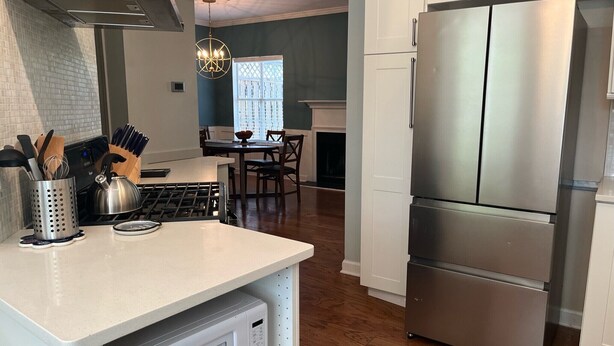 A modern kitchen with a stainless steel refrigerator, a microwave, and a gas stove. - Spectacular 3 BDR Townhouse Near Downtown ATL, GSU (Atlanta)