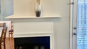 A room with a fireplace, a door with a window, and a chair. - Spectacular 3 BDR Townhouse Near Downtown ATL, GSU (Atlanta)