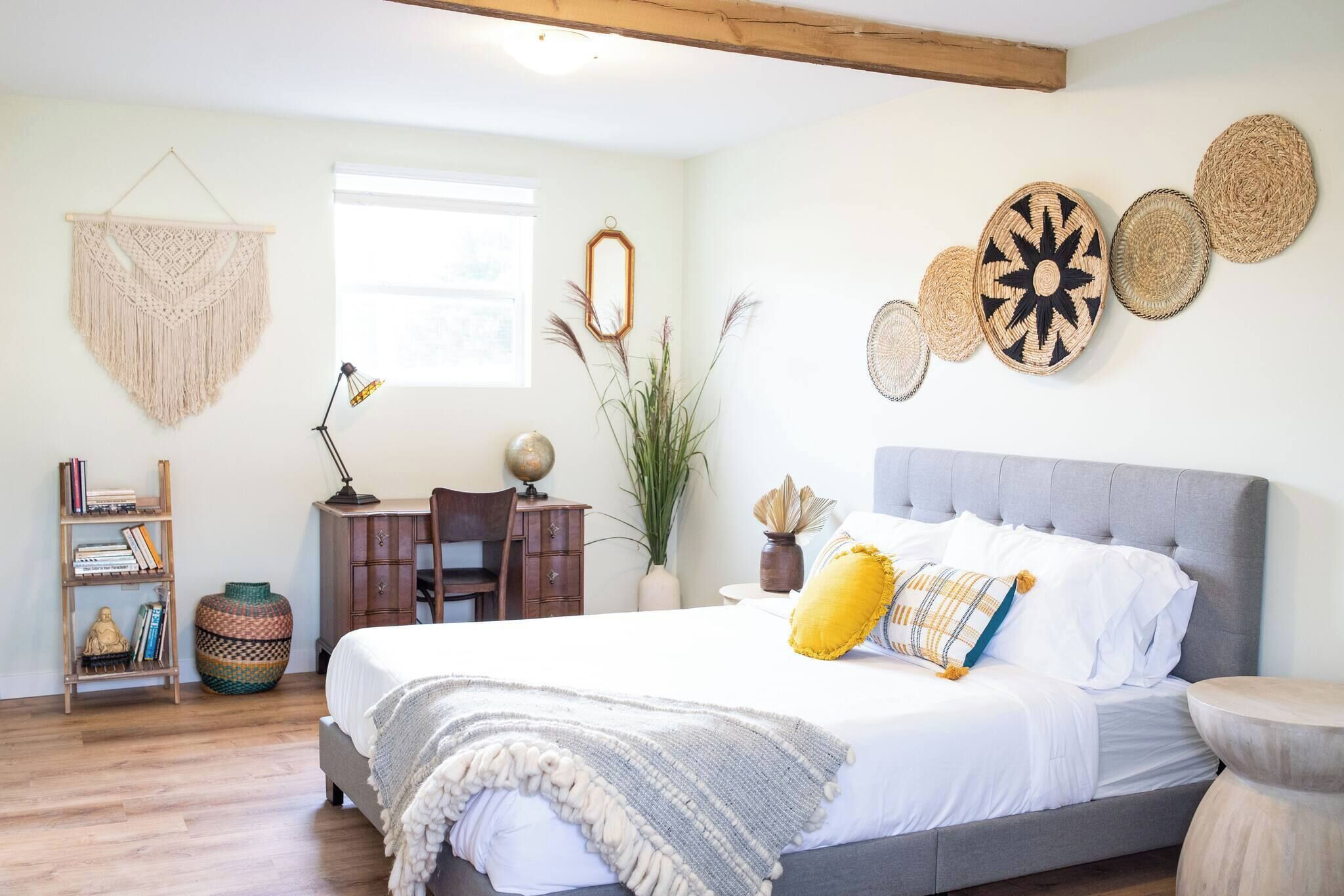 Un dormitorio con cama, mesita de noche, lámpara y elementos decorativos.