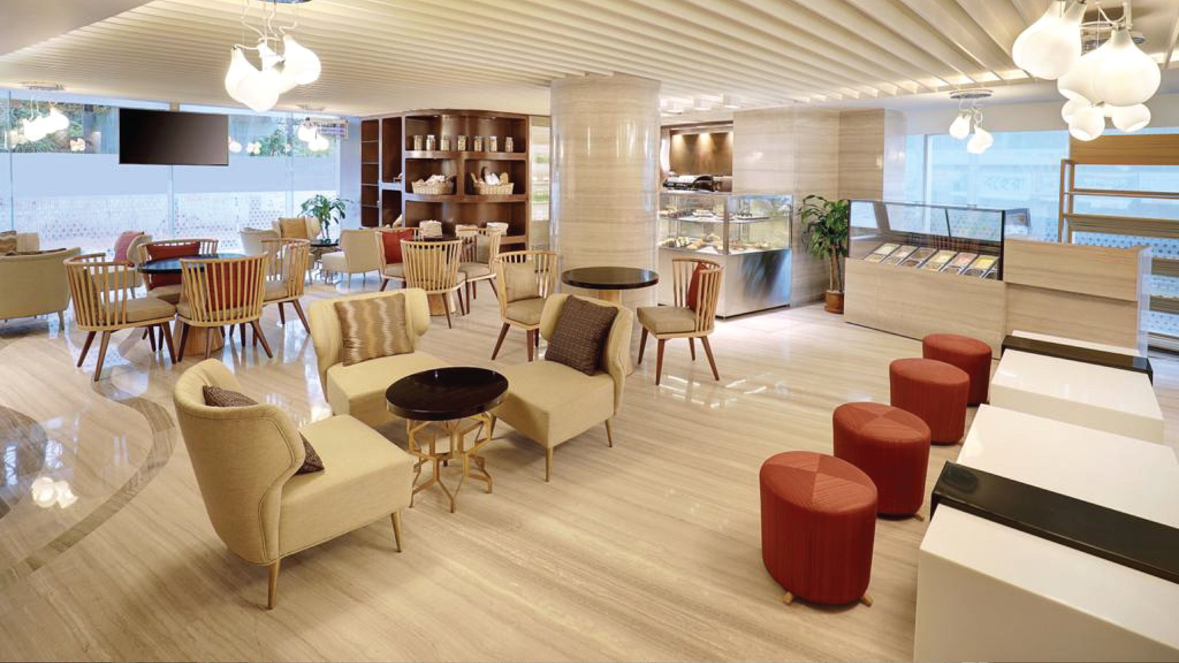 A modern lounge area with sofas, chairs, and a coffee bar.