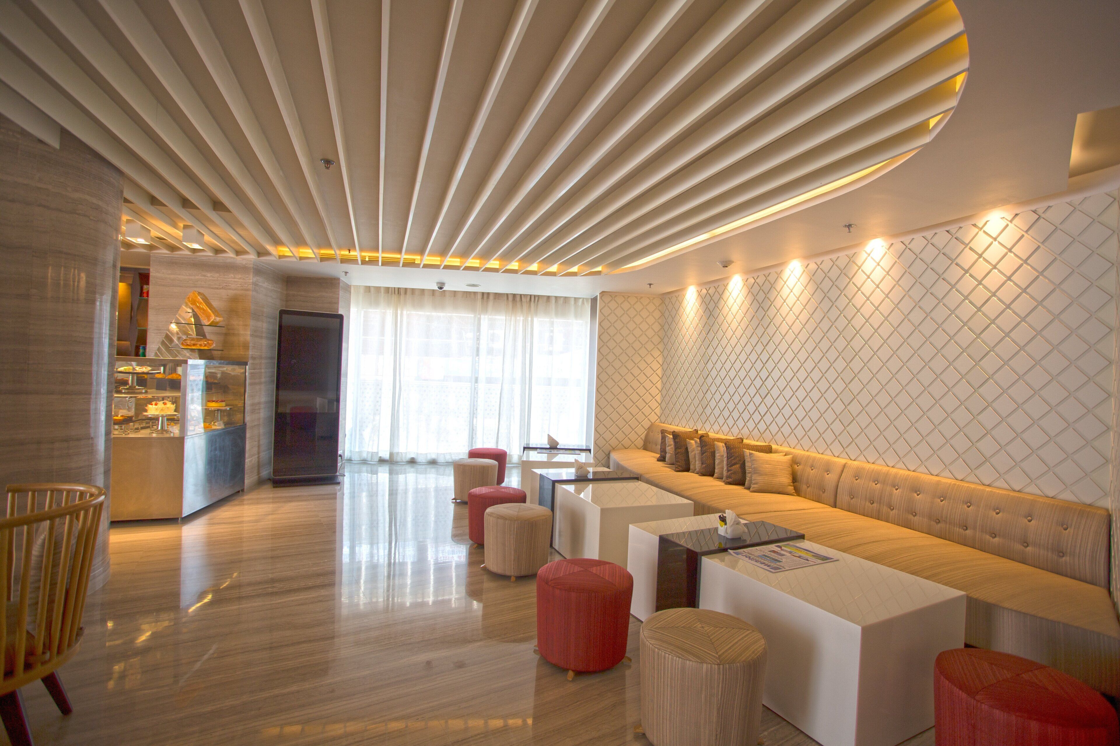 A modern interior with a wooden floor, a sofa set, and a dining area with a glass partition.