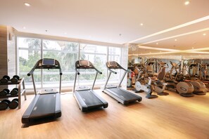 Een sportschool met loopbanden, gewichten en diverse fitnessapparaten.