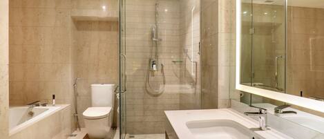 A modern bathroom with a glass-enclosed shower, a toilet, a bathtub, and a large mirror.