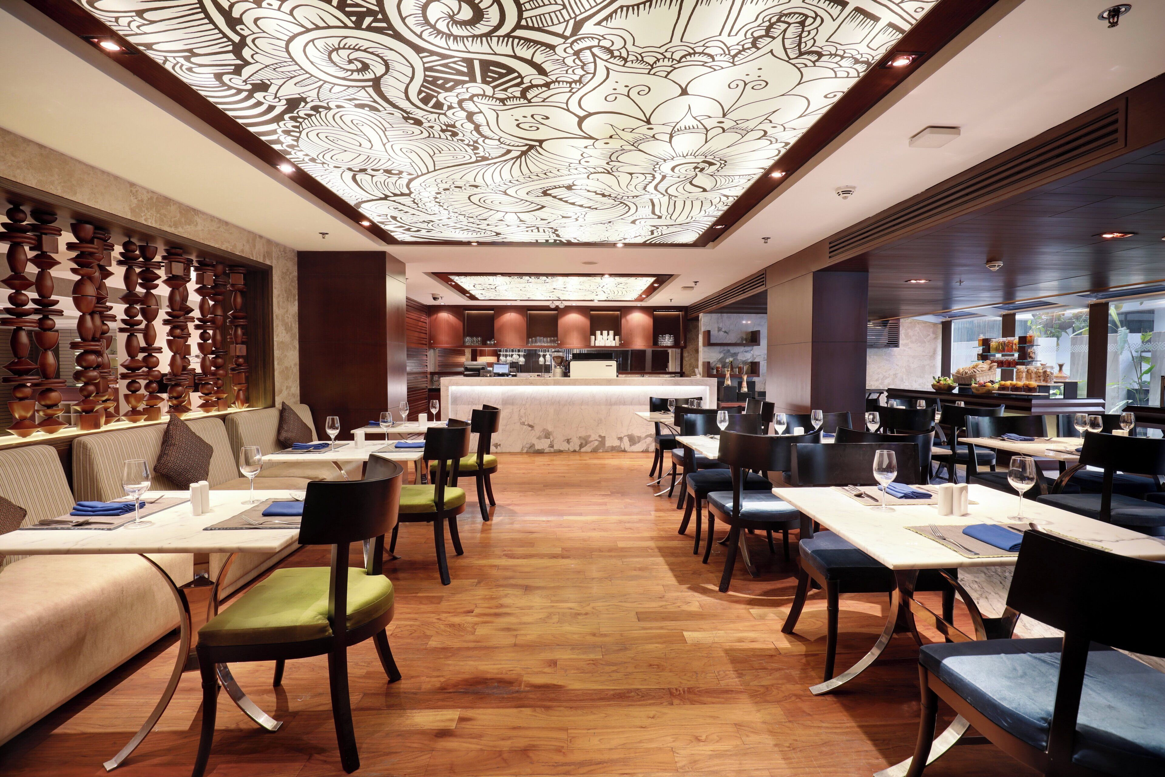 A restaurant with a central bar, booths, and tables with chairs.