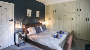 Une chambre à coucher avec un lit, une table de chevet et une armoire.