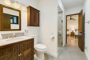 A modern bathroom with a large mirror, wooden cabinets, a white sink, and a toilet. - 5 King Beds, City/Mountain Views, Pool, 1 story ranch-style home, foothills (Catalina Foothills)