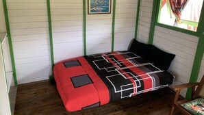 A room with a bed, a framed picture on the wall, and a window with a curtain. - Bungalow for 2 persons (Les Trois-Îlets)